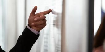 Person's hand pointing to a presentation board